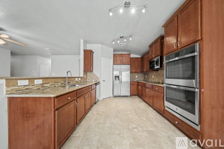 A kitchen with wooden cabinets and a marble countertop.