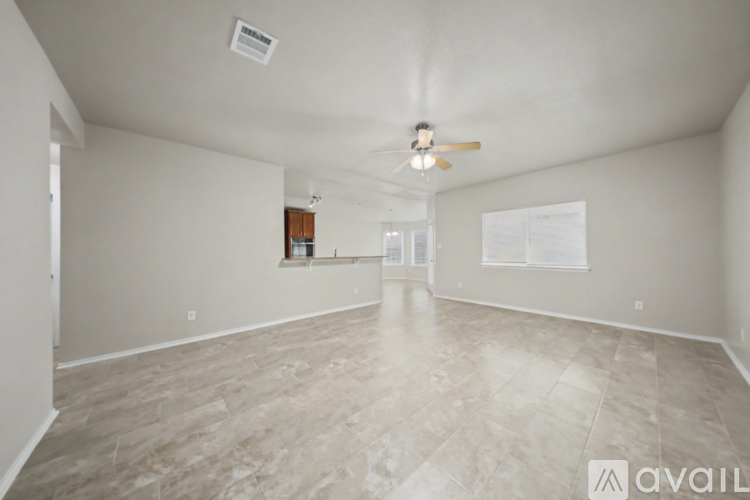 A spacious room with a ceiling fan and a light fixture.