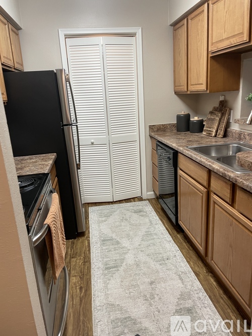 A kitchen with a black refrigerator and white closed doors.