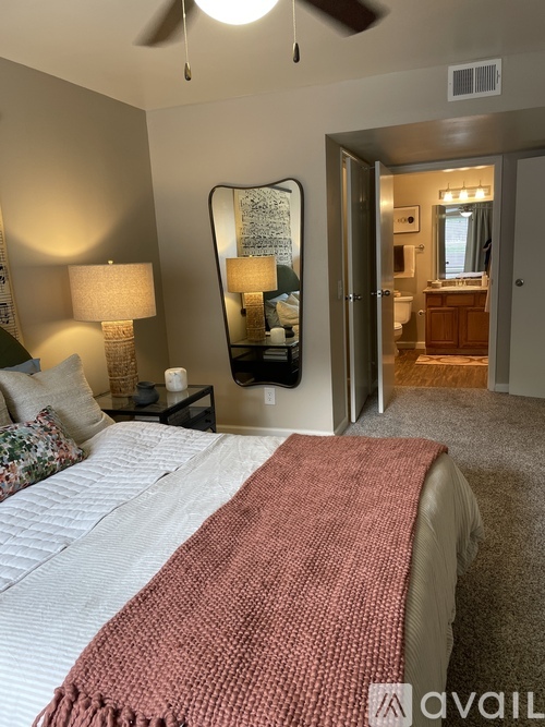 A bedroom with a large bed and a mirror on the wall.
