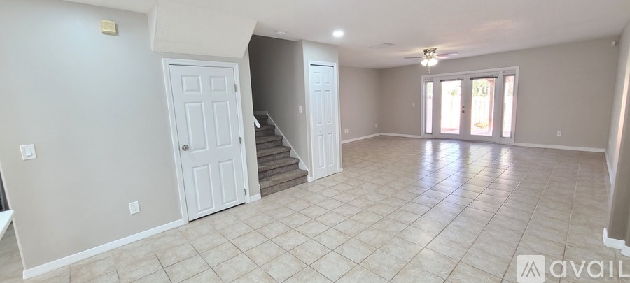 A spacious living room with a staircase leading to the upper floor.