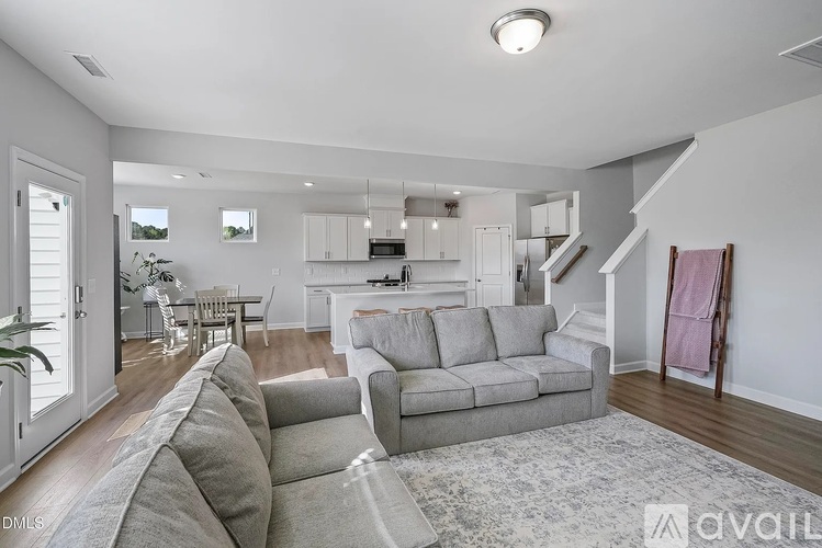 A living room with a grey couch and a rug.