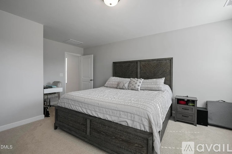 A bedroom with a large bed and a nightstand.