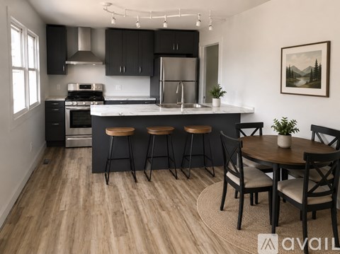 A kitchen with a table and chairs in front of it.