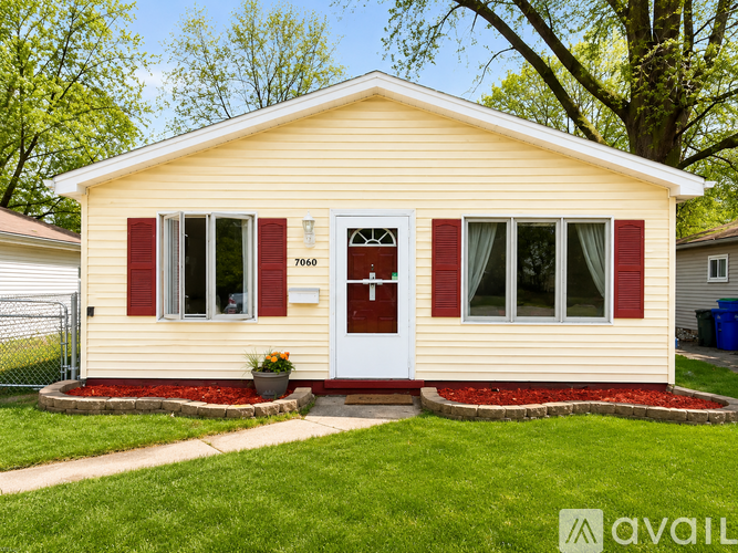 A small house with a red door and windows is for sale.