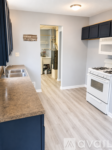 A kitchen with a white stove and a sink.