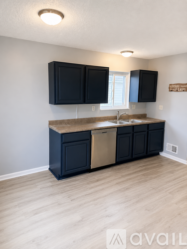 A kitchen with black cabinets and a wooden island.
