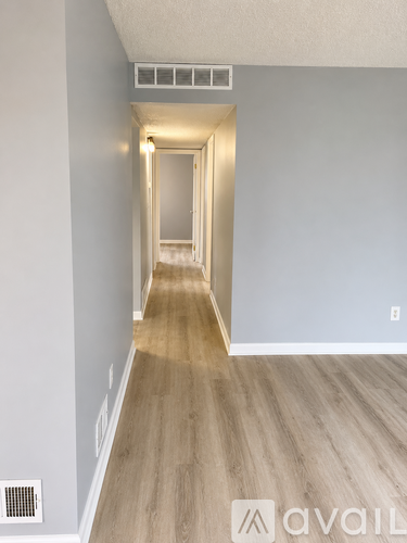 A long hallway with wooden floors and white walls.