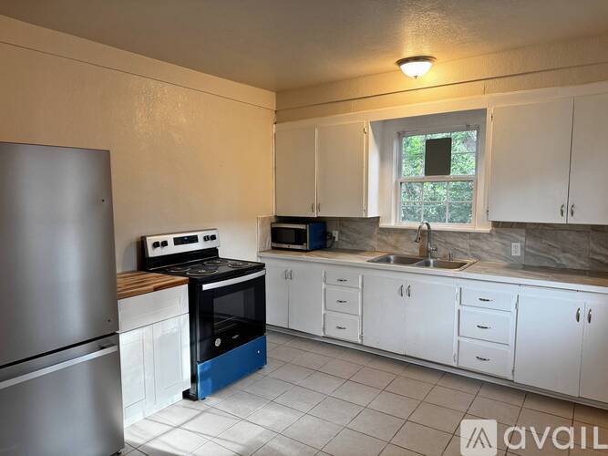 A kitchen with white cabinets and a blue drawer.