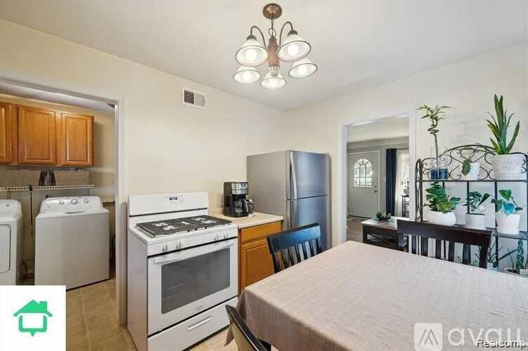A kitchen with a white stove top oven and a white refrigerator.