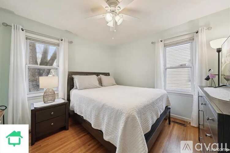 A bedroom with a bed, nightstand, and window.