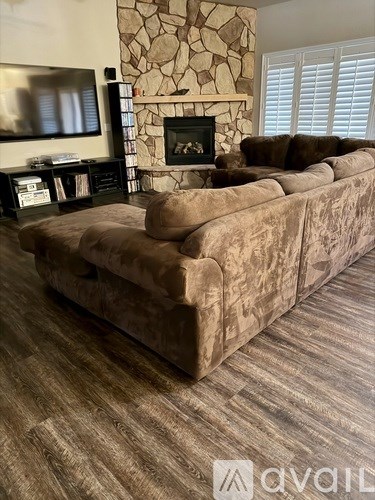A large sectional sofa in a living room with a stone fireplace.