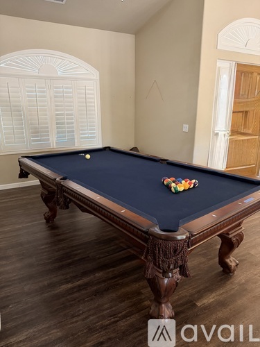 A pool table with a blue felt cloth and a set of colorful pool balls.