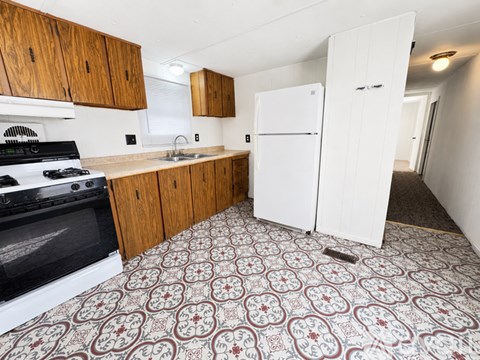 A kitchen with a black stove top oven and a white refrigerator.
