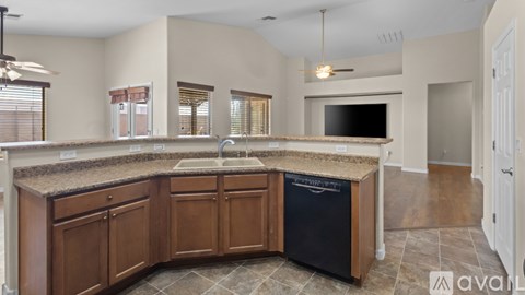 A kitchen with wooden cabinets and a black dishwasher.