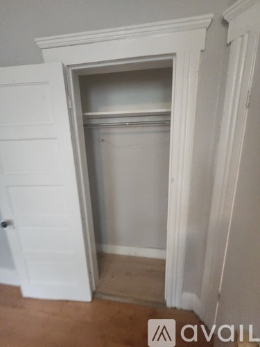 A white door is open to a small, empty room.