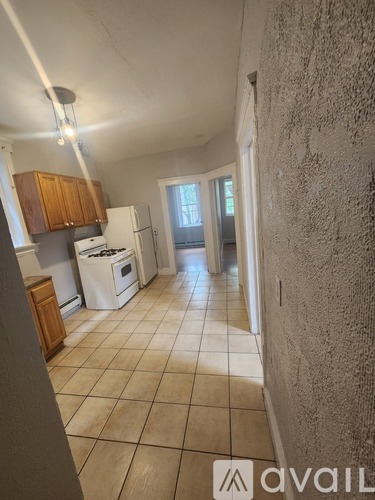 A kitchen with tile flooring and a wall with a textured pattern.