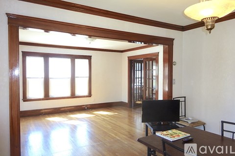 A living room with a television and a table with a magazine on it.