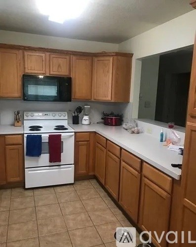 A kitchen with wooden cabinets and a white stove top oven.