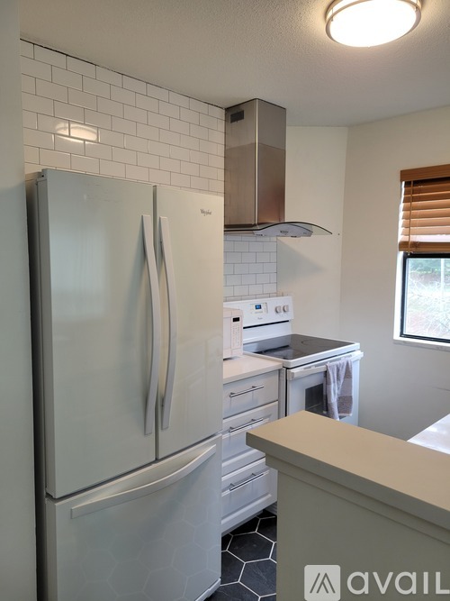A kitchen with a white fridge and a stove top oven.