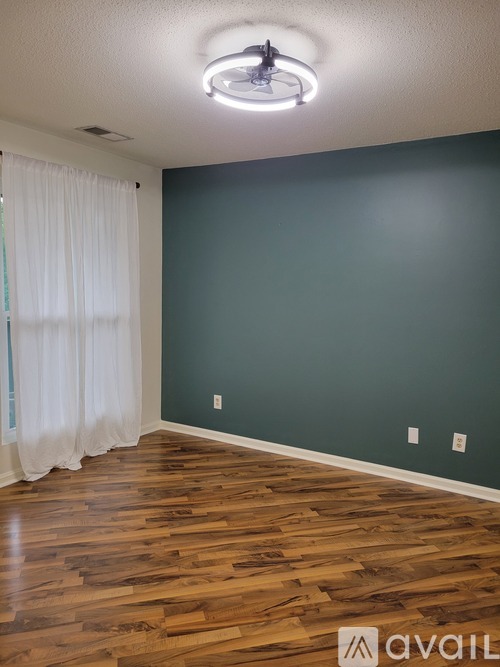 A room with wooden floors and a white ceiling light.