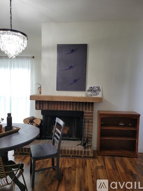 A living room with a fireplace and a painting above it.