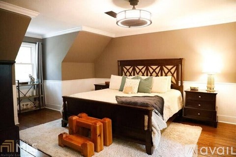 A bedroom with a large bed and a wooden bench.