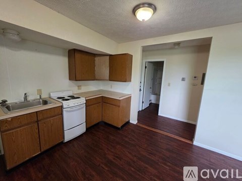 A kitchen with wooden cabinets and a white stove top oven.