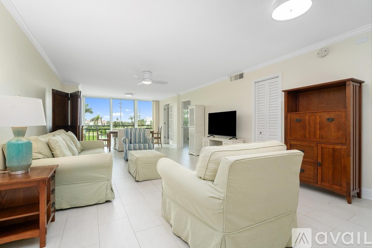 A living room with a white couch and a wooden cabinet.