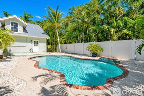 A white house with a pool in the backyard.