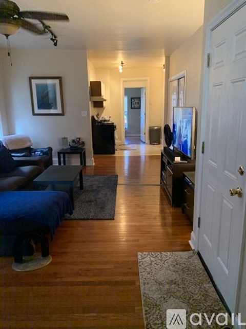 A living room with a black couch and a television.
