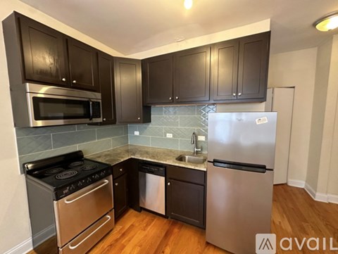 A kitchen with dark brown cabinets and stainless steel appliances.
