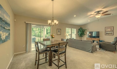 A living room with a dining table and chairs.