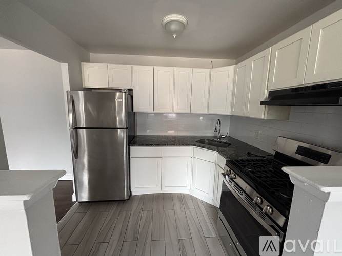 A kitchen with a stainless steel refrigerator and black stove.