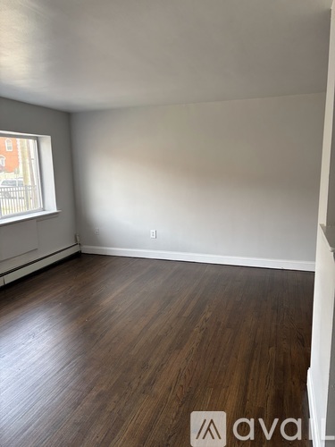 A room with wooden flooring and a window.