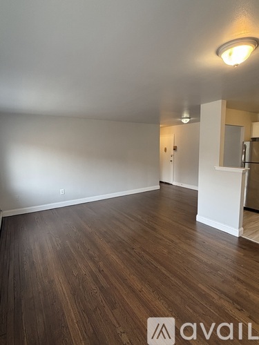 A room with wooden flooring and a white wall.