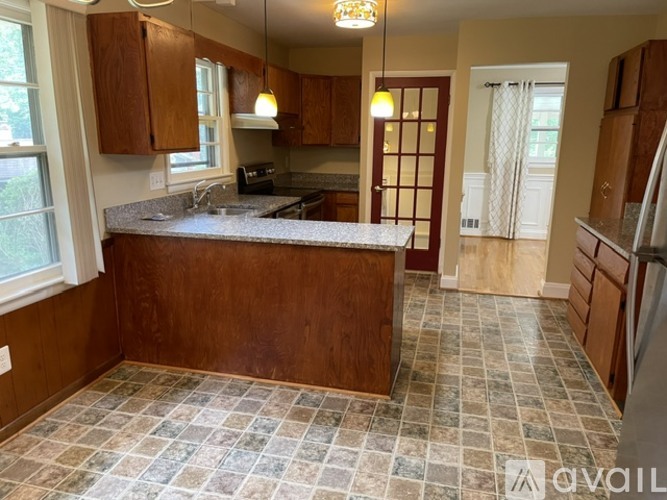 A kitchen with brown cabinets and a checkered floor.