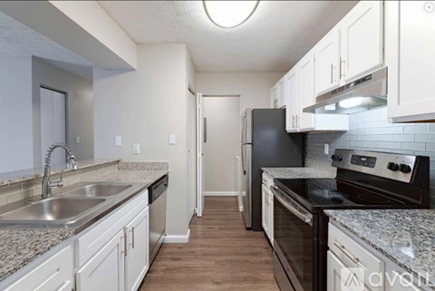 A kitchen with a black refrigerator and stove top oven.