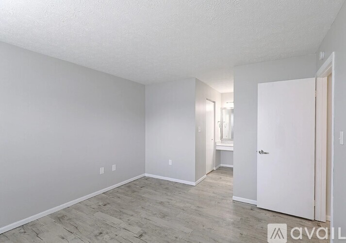 A spacious room with a door on the right and a window on the left.