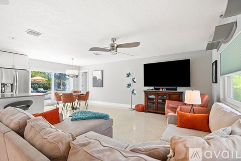 A living room with a large couch and a television on the wall.