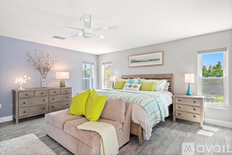 A bedroom with a bed, dresser, and nightstand with lamps.