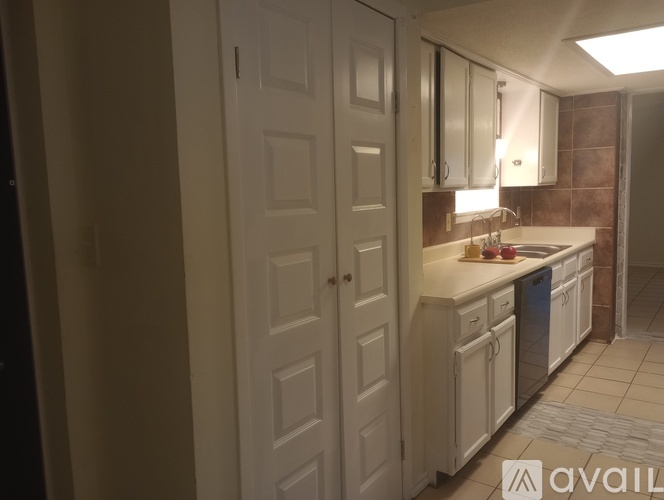 A kitchen with white cabinets and a sink.