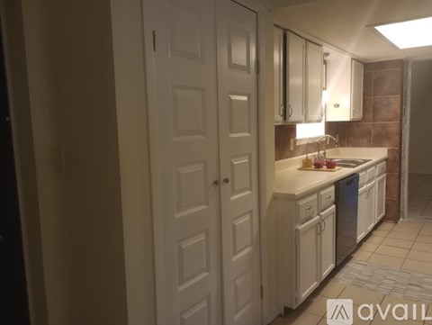 A kitchen with white cabinets and a sink.