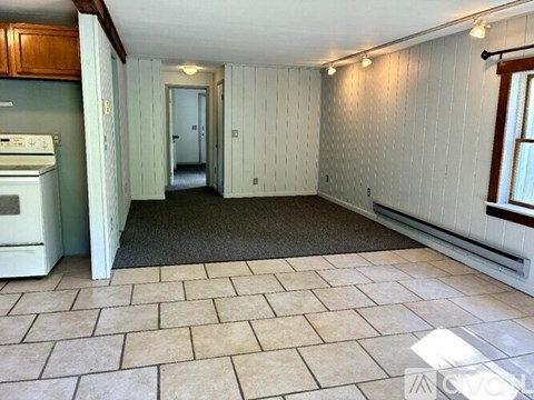 A kitchen with a stove and a tiled floor.
