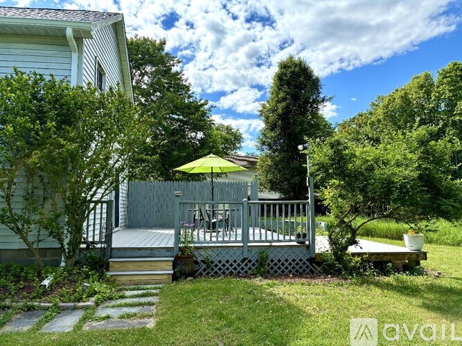 A house with a deck and patio surrounded by trees.