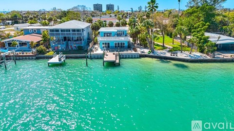 A blue building is situated on a dock with a boat in front of it.
