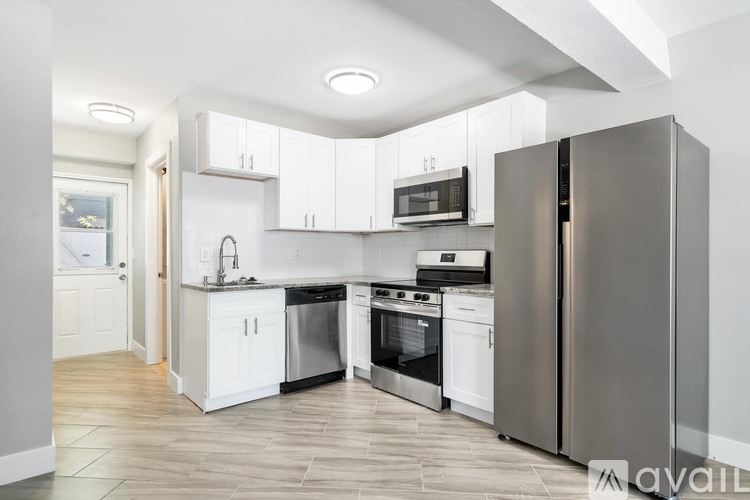 A kitchen with white cabinets and stainless steel appliances.