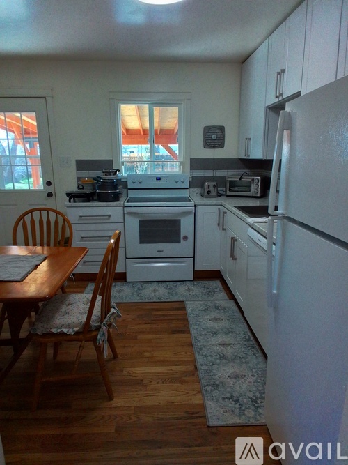 A kitchen with a table and chairs in front of a stove.