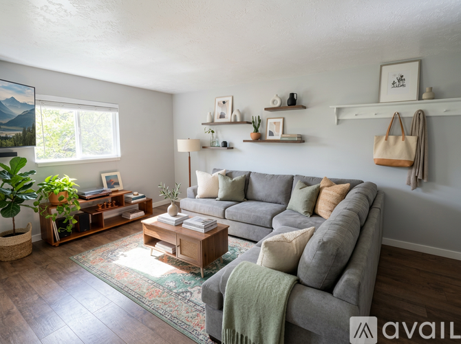 A living room with a grey couch, a wooden coffee table, and a rug on the floor.