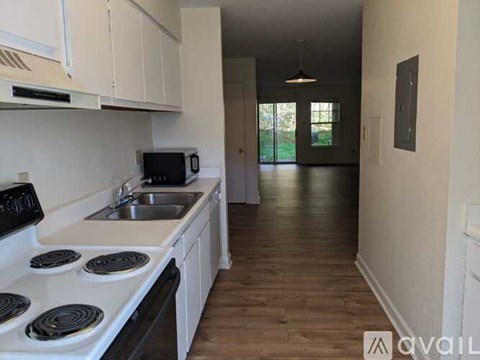 A kitchen with white cabinets and a stove top oven.